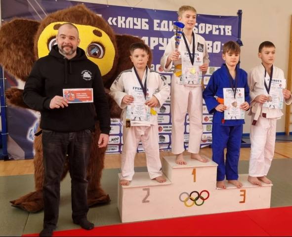 Тренер и ребята на пьедестале с грамотами
